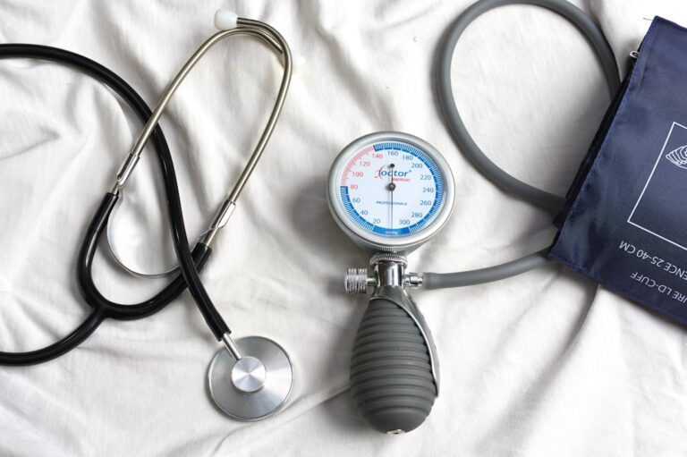 An older adult checks their blood pressure at home with a digital arm cuff.